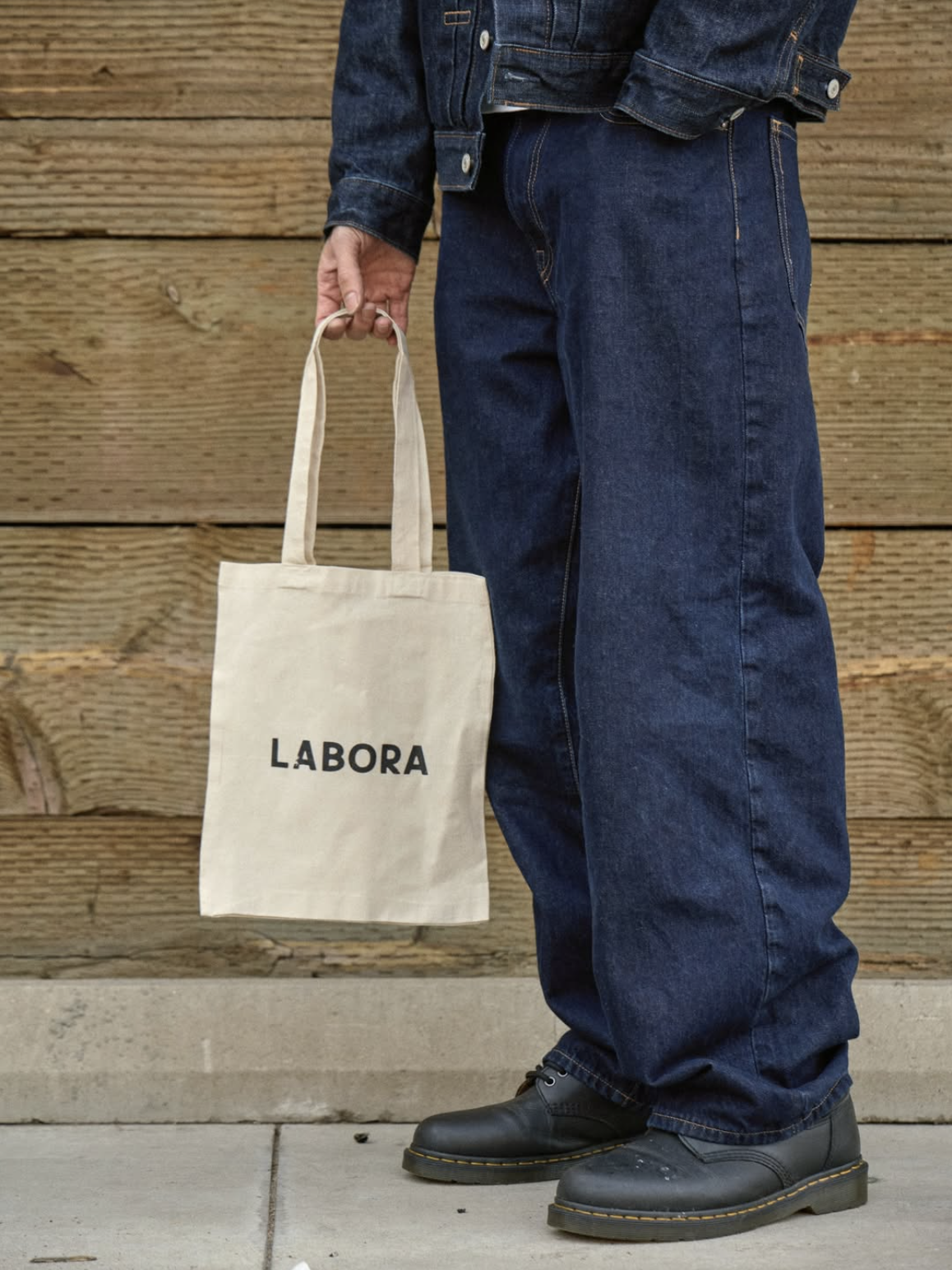 A customer carrying a Labora canvas tote bag outside the cafe
